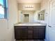 Bathroom showcases dual sinks, granite counters, wood cabinets, and a large mirror at 2241 Chandler Ranch Pl, Laughlin, NV 89029