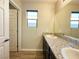 Bathroom features granite counters, a sink, large mirror, and wood-look tile floor at 2241 Chandler Ranch Pl, Laughlin, NV 89029