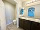 Main bathroom featuring a dual sink vanity with granite counters and wood look floors at 2241 Chandler Ranch Pl, Laughlin, NV 89029