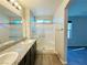 Bright bathroom featuring a dual sink vanity with granite counters and a glass-enclosed shower at 2241 Chandler Ranch Pl, Laughlin, NV 89029