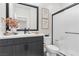 Modern bathroom featuring dark vanity, framed mirror, and tiled shower with glass door at 2493 Verdello St, Henderson, NV 89044