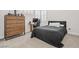 This bedroom includes a wooden dresser, desk, and a black bedspread at 2493 Verdello St, Henderson, NV 89044