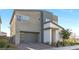 Beautiful modern-style home with a gray color scheme, modern garage door and well-manicured landscaping at 2493 Verdello St, Henderson, NV 89044