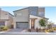 Contemporary two-story home with modern garage door, neutral colors and a brick driveway at 2493 Verdello St, Henderson, NV 89044