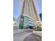 Modern high-rise exterior with a glass facade, palm trees, and clear blue skies at 2700 Las Vegas Blvd # 1604, Las Vegas, NV 89109
