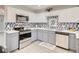 Modern kitchen with stainless steel appliances, white cabinets, and gray countertops at 2712 Royal St, North Las Vegas, NV 89030