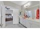 Well-lit bathroom featuring double sinks, white cabinets, and an adjacent bedroom view for a modern, open feel at 3037 Villanelle Ave, Henderson, NV 89044