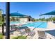 Community pool with lounge chairs and shade canopies on a sunny day at 3037 Villanelle Ave, Henderson, NV 89044