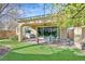 Outdoor patio with a dining set, lush turf, and a ceiling fan for comfortable outdoor entertaining at 3037 Villanelle Ave, Henderson, NV 89044