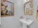 Stylish powder room featuring a pedestal sink and decorative mirror and art at 3037 Villanelle Ave, Henderson, NV 89044