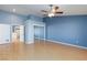 A cozy blue bedroom with light wood flooring, a ceiling fan, and a closet with mirrored sliding doors at 3109 Bangor Ct, Las Vegas, NV 89134