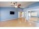 Large bedroom featuring light wood flooring, a ceiling fan, a tv, and closet with mirrored sliding doors at 3109 Bangor Ct, Las Vegas, NV 89134