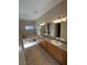 Bathroom featuring double sinks with granite countertops, tiled floors, and a bathtub at 3177 Rabbit Creek Dr, Las Vegas, NV 89120