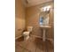 Neutral half bathroom featuring a pedestal sink, toilet, and tile flooring at 3177 Rabbit Creek Dr, Las Vegas, NV 89120