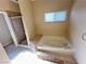 Large tub with stone accents, window, and tile flooring in bathroom at 3177 Rabbit Creek Dr, Las Vegas, NV 89120