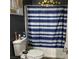 Bathroom features a shower-tub combo with a blue and white striped shower curtain at 3318 N Decatur Blvd # 2057, Las Vegas, NV 89130