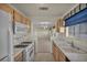 Galley style kitchen with gas range, wood cabinets, and view to the dining area at 3412 Winterhaven St # 101, Las Vegas, NV 89108