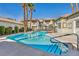 Community pool surrounded by lush landscaping, tall palm trees, and a secure fence for resident enjoyment at 3412 Winterhaven St # 101, Las Vegas, NV 89108