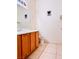 Cozy half bathroom with a wooden vanity, tile flooring, and modern fixtures at 3438 Ceremony Dr, Las Vegas, NV 89117