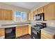 Bright kitchen featuring wood cabinets, black appliances, and grey countertops at 3941 Yellow Mandarin Ave, North Las Vegas, NV 89081