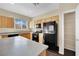 Bright kitchen featuring wooden cabinets, black appliances, and a spacious countertop at 3941 Yellow Mandarin Ave, North Las Vegas, NV 89081