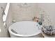 Cozy tub featuring white pebble tiling, silver hardware, and convenient bath caddy at 4300 S Gressa St, Pahrump, NV 89061