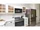 Well-lit kitchen featuring stainless steel appliances, white cabinets with glass, and a subway tile backsplash at 4300 S Gressa St, Pahrump, NV 89061