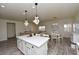 Open-concept kitchen with a center island, dining area, and sleek flooring in a neutral palette at 4300 S Gressa St, Pahrump, NV 89061