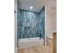 Modern bathroom features blue tiled shower over tub and updated fixtures and toilet at 4412 Denia Cir, Las Vegas, NV 89108