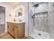 Bright bathroom showcasing a double vanity, a glass-enclosed shower with vertical tiles, and modern fixtures at 4412 Denia Cir, Las Vegas, NV 89108