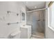 Bright bathroom featuring a sleek vanity, glass shelves, and a modern shower with stylish tile at 4606 Cory Pl, Las Vegas, NV 89107