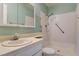 Well-lit bathroom featuring a walk-in shower and a vanity with a light green wall at 4648 Comnor Hill Ln, Las Vegas, NV 89121