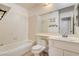 Clean bathroom with a tub, toilet and sink with mirror that overlooks the toilet and sink at 4648 Comnor Hill Ln, Las Vegas, NV 89121