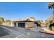 Charming townhome featuring attached garages and stucco siding, set against a backdrop of mature trees and clear blue skies at 4648 Comnor Hill Ln, Las Vegas, NV 89121