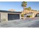 Townhome featuring assigned garage parking with stucco exterior, complemented by landscaping and blue skies at 4648 Comnor Hill Ln, Las Vegas, NV 89121