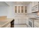 Bright kitchen with white appliances, tile counters, and white cabinets with a light fixture at 4648 Comnor Hill Ln, Las Vegas, NV 89121