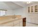 Cozy kitchen with white cabinets and countertops with tile flooring and a double basin sink at 4648 Comnor Hill Ln, Las Vegas, NV 89121