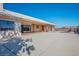 Expansive backyard featuring a large concrete patio, mature trees casting shadows, and a white tiled roof at 4911 W Pebble Rd, Las Vegas, NV 89139