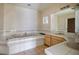 Relaxing bathroom featuring a large soaking tub, dual sinks, and tiled accents for a comfortable experience at 4911 W Pebble Rd, Las Vegas, NV 89139