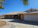 Brick single-story home with a two car garage and desert landscaping and a long driveway at 4911 W Pebble Rd, Las Vegas, NV 89139