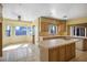 Sunlit kitchen area with a breakfast nook, tiled countertops, light wood cabinets, and updated appliances at 4911 W Pebble Rd, Las Vegas, NV 89139