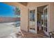 Covered patio area featuring tiled flooring, a textured ceiling, and entry to the home through glass paneled double doors at 4911 W Pebble Rd, Las Vegas, NV 89139