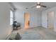 Bright bedroom with neutral carpet, ceiling fan, and a door to the bathroom at 5382 El Nevero St, Las Vegas, NV 89166