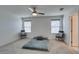 Spacious bedroom featuring two windows, ceiling fan, and neutral colored carpet at 5382 El Nevero St, Las Vegas, NV 89166