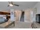 Inviting living room featuring a ceiling fan, staircase, and an adjacent kitchen at 5382 El Nevero St, Las Vegas, NV 89166