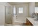 Bright bathroom features a glass-enclosed shower, soaking tub, and vanity with sink at 5827 Delonee Skies Ave, Las Vegas, NV 89131