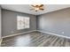 Comfortable bedroom with a ceiling fan, gray walls, and wood-look flooring at 5827 Delonee Skies Ave, Las Vegas, NV 89131