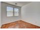 A bright bedroom with two windows, a closet, neutral walls, and stained concrete flooring at 5827 Delonee Skies Ave, Las Vegas, NV 89131