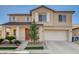 Two-story home featuring a red front door, desert landscaping, and an attached two car garage at 5827 Delonee Skies Ave, Las Vegas, NV 89131