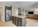 An open-concept kitchen features an island, stainless steel appliances, and a view to the living room at 5827 Delonee Skies Ave, Las Vegas, NV 89131